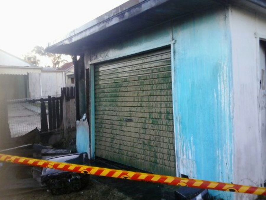 Damaged shed with asbestos cladding about to be safely removed.